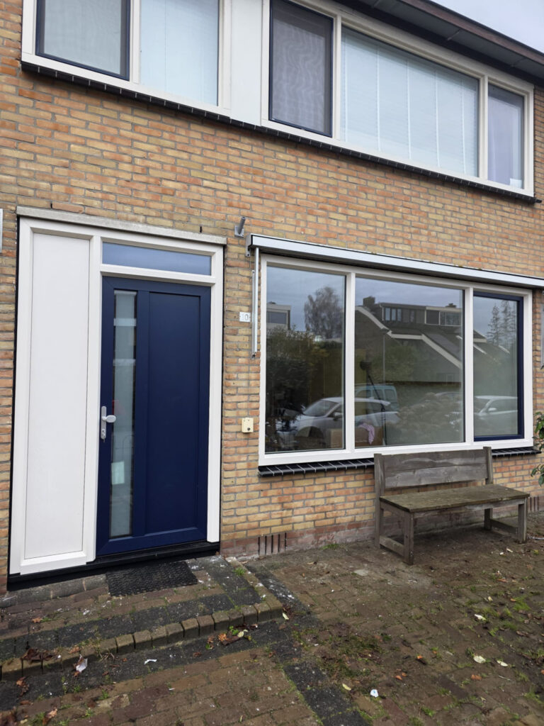 Kunststof kozijnen Creme houtnerf met Staalblauwe voordeur te Hoogkarspel